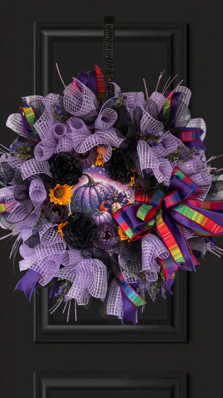 Velvet Eclipse luxury handmade Halloween wreath featuring lavender deco mesh, black florals, colorful designer ribbon bow, sunflowers, and a whimsical purple pumpkin centerpiece displayed on a black front door.