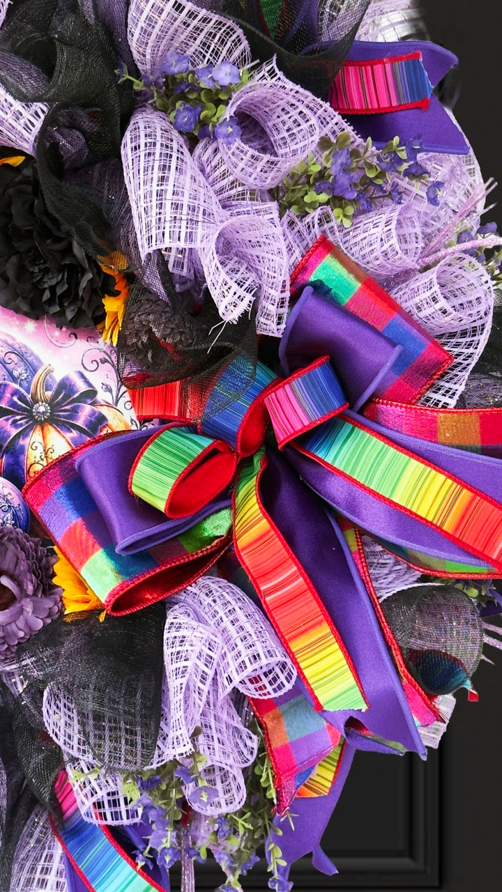 Velvet Eclipse luxury handmade Halloween wreath featuring lavender deco mesh, black florals, colorful designer ribbon bow, sunflowers, and a whimsical purple pumpkin centerpiece displayed on a black front door.