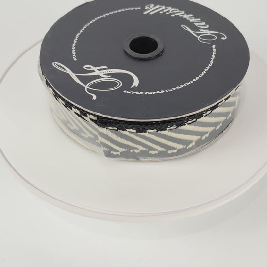 Farrisilk Shapeshifter black and white geometric wired ribbon, 1 inches wide, displayed on a full 10-yard spool with decorative ribbon loops.