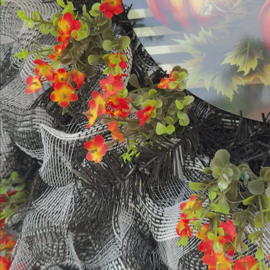 Harlequin Harvest Manor Wreath featuring lavender deco mesh, black florals, vibrant harlequin ribbon, sunflowers, and a whimsical purple pumpkin centerpiece displayed on a black front door.