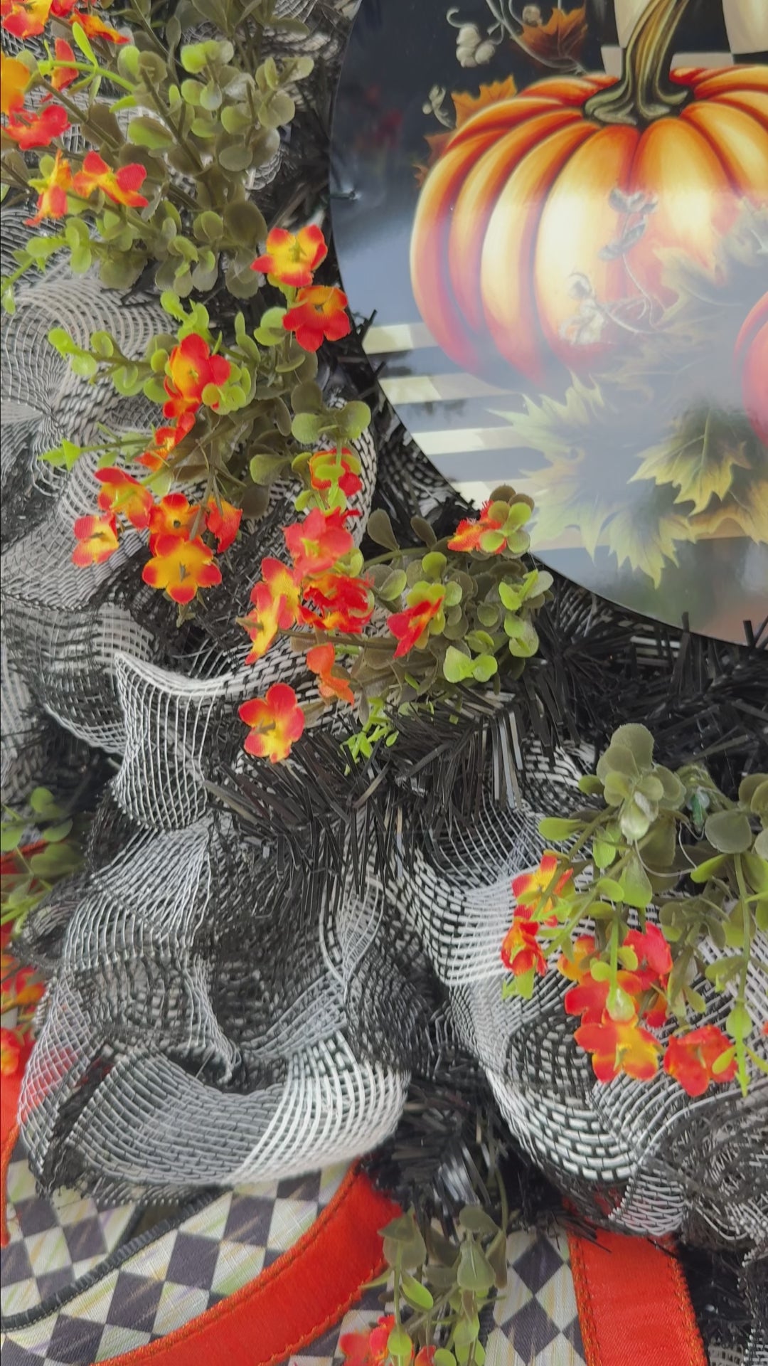 Harlequin Harvest Manor Wreath featuring lavender deco mesh, black florals, vibrant harlequin ribbon, sunflowers, and a whimsical purple pumpkin centerpiece displayed on a black front door.