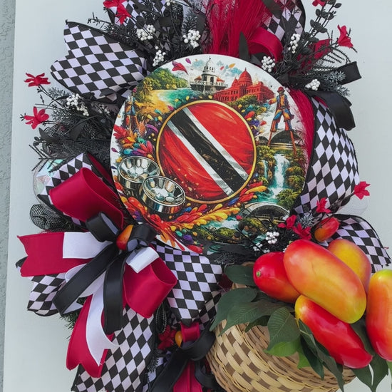 Handmade Trinidad and Tobago Caribbean front door wreath featuring a colorful Trinidad flag centerpiece, red black and white decorative bows, tropical greenery and woven basket filled with artificial peppers.
