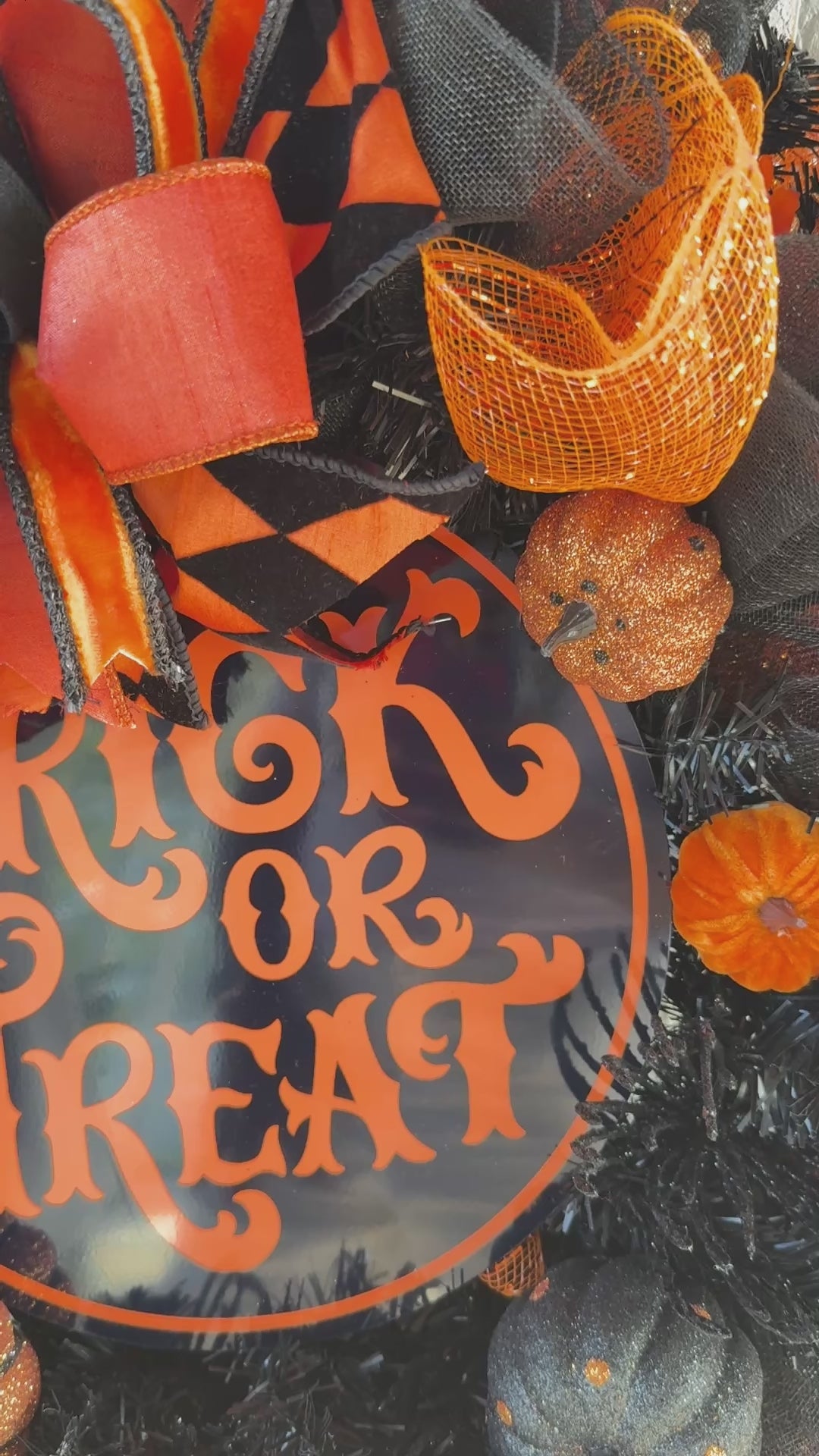 Black and orange Halloween wreath with layered mesh, designer ribbons, fall leaves, glitter pumpkins, and a round “Trick or Treat” sign.