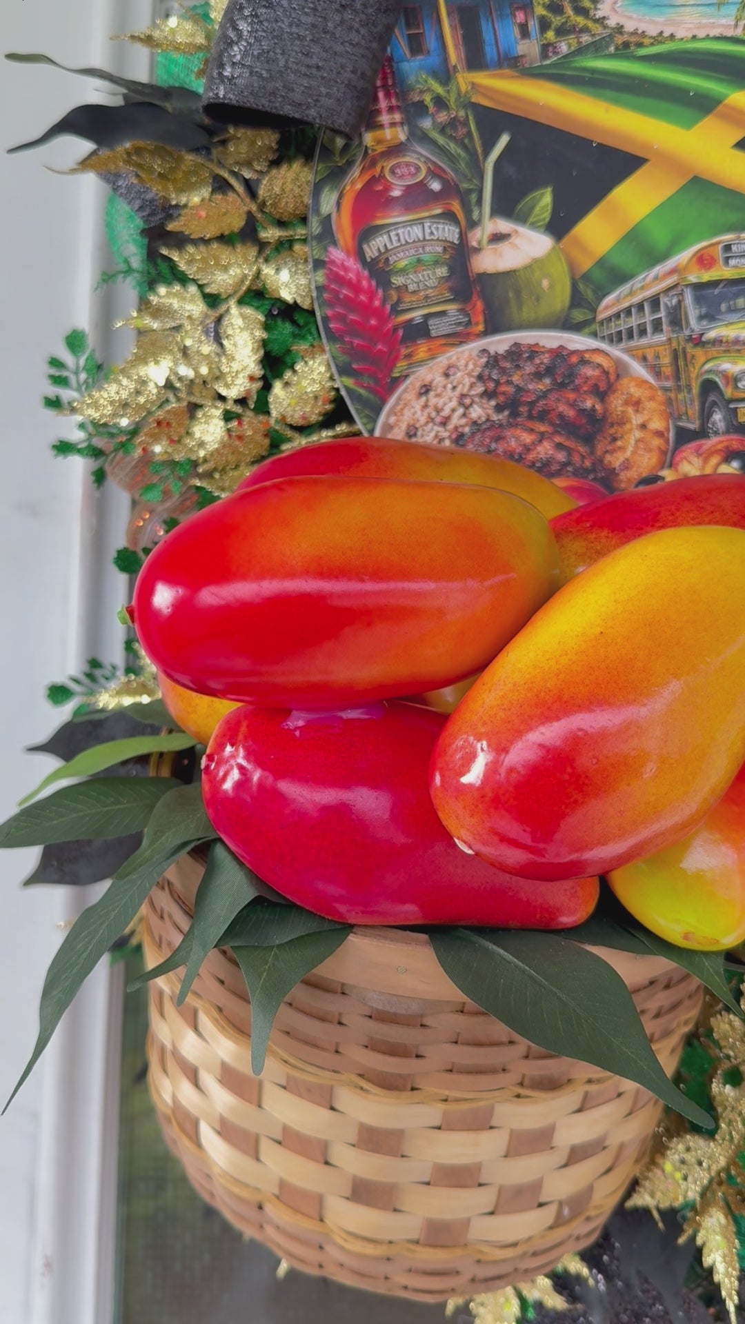 Luxury handmade Jamaica-inspired door wreath featuring green, black, and gold designer ribbons, tropical fruit basket, glittered foliage, and colorful island-themed artwork celebrating Jamaican culture and Caribbean décor.