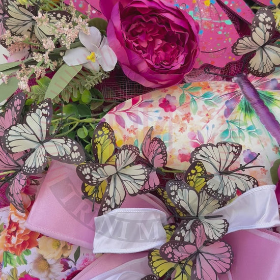 Handmade pink butterfly wreath featuring vibrant florals, layered designer ribbons, lush greenery, and colorful butterflies. This whimsical spring and summer front door wreath creates a beautiful statement piece perfect for entryways, porch decor, and everyday home decorating.