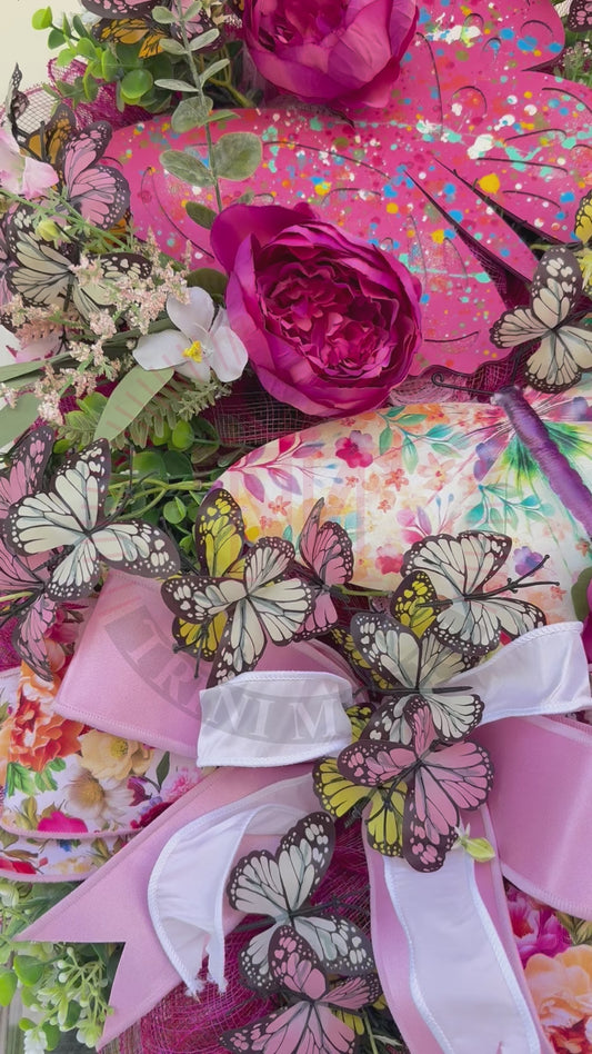 Handmade pink butterfly wreath featuring vibrant florals, layered designer ribbons, lush greenery, and colorful butterflies. This whimsical spring and summer front door wreath creates a beautiful statement piece perfect for entryways, porch decor, and everyday home decorating.