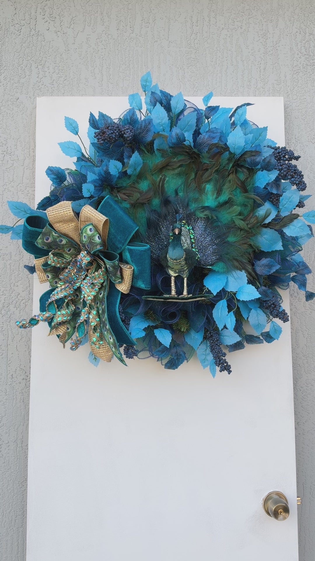 Full view of handmade peacock wreath with measuring tape showing the finished dimensions.