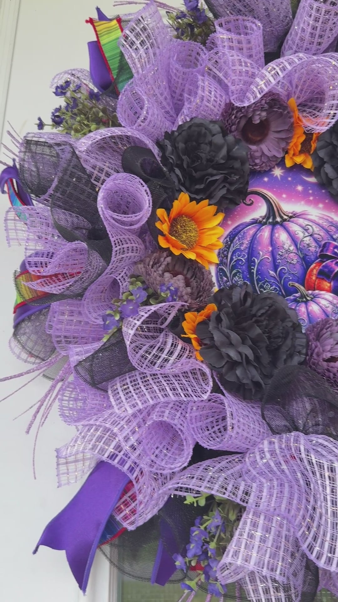 Velvet Eclipse luxury handmade Halloween wreath featuring lavender deco mesh, black florals, colorful designer ribbon bow, sunflowers, and a whimsical purple pumpkin centerpiece displayed on a black front door.